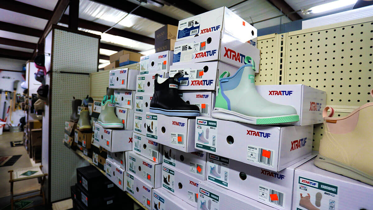 Xtratuf rubber boots stacked on shelves at Hi Grade